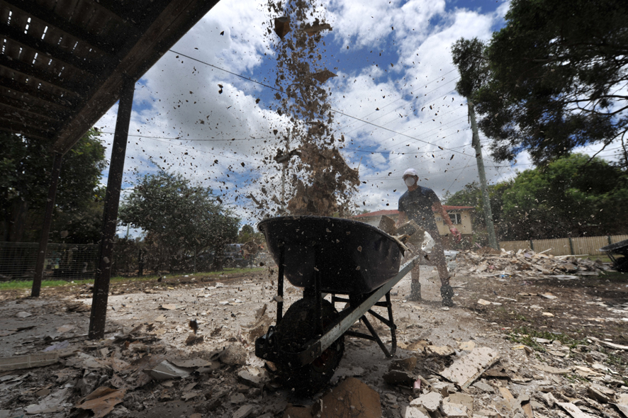 Global Care Volunteers get rid of unwanted gyprick and debris left over from the floods at a house in North Booval, Queensland.