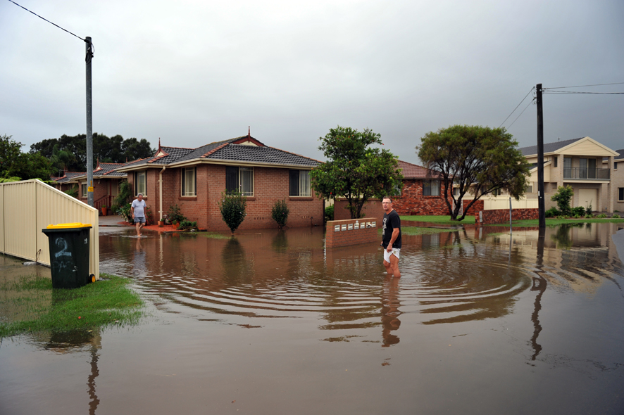 Flood water crosses the intersection of George Street and Susan Ave, Warilla, during flash flooding across the Illawarra region.